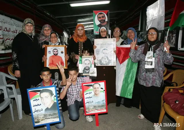 Palestinians take part in a protest calling for the release of Palestinian prisoners from Israeli jails and in support of inmates in hunger strike on October 11, 2011 outside the Red Cross buildings in Jerusalem's Old Ci...