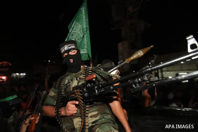 Masked Palestinian Hamas militants celebrate the announcement of a prisoner swap deal with Israel, in the Jebaliya refugee camp northern Gaza Strip, Tuesday, Oct. 11, 2011. Israeli and Hamas have reached a deal to free c...