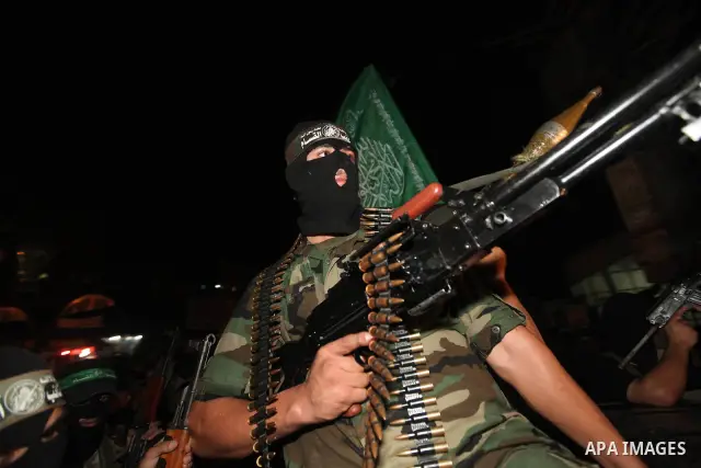 Masked Palestinian Hamas militants celebrate the announcement of a prisoner swap deal with Israel, in the Jebaliya refugee camp northern Gaza Strip, Tuesday, Oct. 11, 2011. Israeli and Hamas have reached a deal to free c...