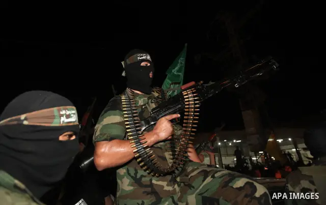 Masked Palestinian Hamas militants celebrate the announcement of a prisoner swap deal with Israel, in the Jebaliya refugee camp northern Gaza Strip, Tuesday, Oct. 11, 2011. Israeli and Hamas have reached a deal to free c...