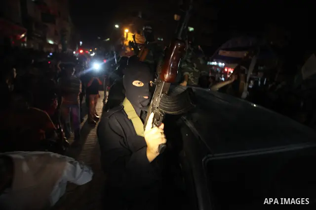 Masked Palestinian Hamas militants celebrate the announcement of a prisoner swap deal with Israel, in the Jebaliya refugee camp northern Gaza Strip, Tuesday, Oct. 11, 2011. Israeli and Hamas have reached a deal to free c...