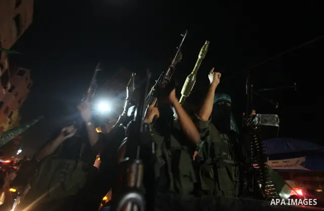 Masked Palestinian Hamas militants celebrate the announcement of a prisoner swap deal with Israel, in the Jebaliya refugee camp northern Gaza Strip, Tuesday, Oct. 11, 2011. Israeli and Hamas have reached a deal to free c...