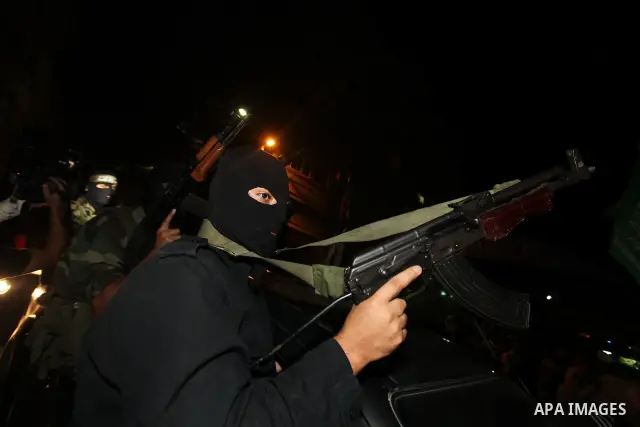 Masked Palestinian Hamas militants celebrate the announcement of a prisoner swap deal with Israel, in the Jebaliya refugee camp northern Gaza Strip, Tuesday, Oct. 11, 2011. Israeli and Hamas have reached a deal to free c...