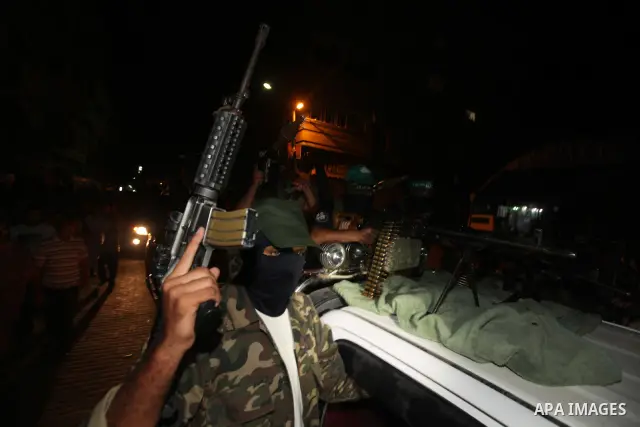 Masked Palestinian Hamas militants celebrate the announcement of a prisoner swap deal with Israel, in the Jebaliya refugee camp northern Gaza Strip, Tuesday, Oct. 11, 2011. Israeli and Hamas have reached a deal to free c...