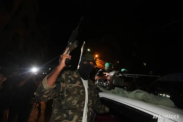 Masked Palestinian Hamas militants celebrate the announcement of a prisoner swap deal with Israel, in the Jebaliya refugee camp northern Gaza Strip, Tuesday, Oct. 11, 2011. Israeli and Hamas have reached a deal to free c...