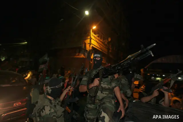 Masked Palestinian Hamas militants celebrate the announcement of a prisoner swap deal with Israel, in the Jebaliya refugee camp northern Gaza Strip, Tuesday, Oct. 11, 2011. Israeli and Hamas have reached a deal to free c...