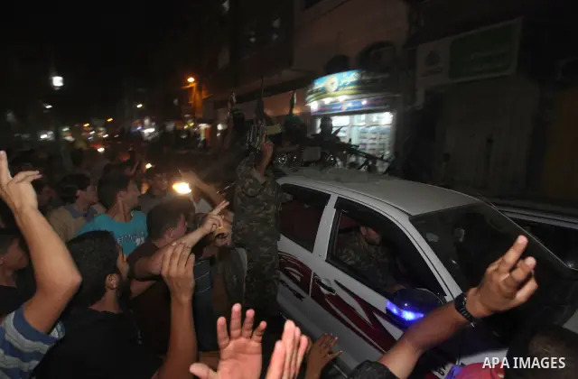 Masked Palestinian Hamas militants celebrate the announcement of a prisoner swap deal with Israel, in the Jebaliya refugee camp northern Gaza Strip, Tuesday, Oct. 11, 2011. Israeli and Hamas have reached a deal to free c...