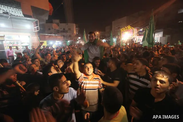 Palestinian Hamas supporters celebrate the announcement of a prisoner swap deal with Israel, in the Jebaliya refugee camp, northern Gaza Strip, Tuesday, Oct. 11, 2011. Israeli and Hamas have reached a deal to free captur...