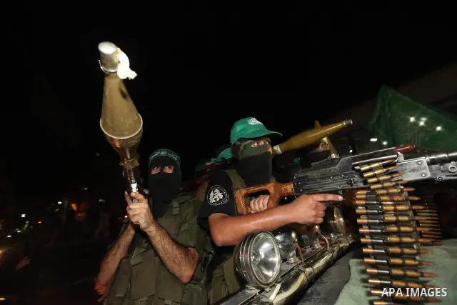 Masked Palestinian Hamas militants celebrate the announcement of a prisoner swap deal with Israel, in the Jebaliya refugee camp northern Gaza Strip, Tuesday, Oct. 11, 2011. Israeli and Hamas have reached a deal to free c...