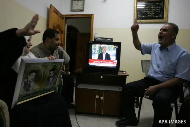 The Family of Hassan Salame, watch a television broadcasting the speech of Hamas leader Khaled Meshaal, celebrating a deal that will see Palestinian detainees freed in exchange for Israeli soldier Gilad Shalit, Hassan Sa...