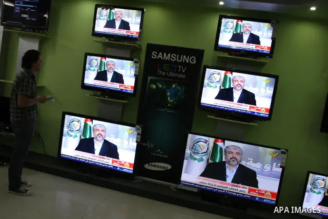 A Palestinian Man watch a television broadcasting the speech of Hamas leader Khaled Meshaal celebrating a deal that will see Palestinian detainees freed in exchange for Israeli soldier Gilad Shalit on October 11, 2011, i...