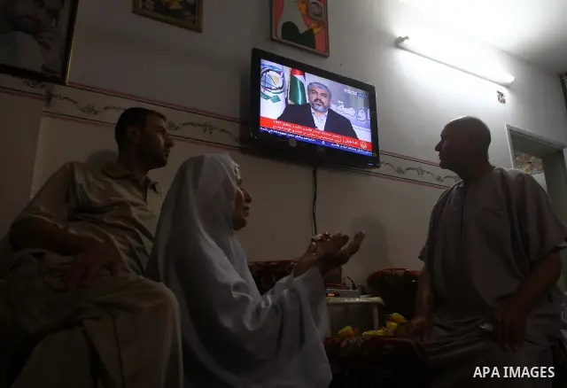 The Family of Mohammed al-Falet, watch a television broadcasting the speech of Hamas leader Khaled Meshaal, celebrating a deal that will see Palestinian detainees freed in exchange for Israeli soldier Gilad Shalit, Moham...
