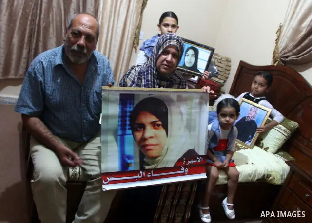 The family of Palestinian prisoner Wafa Albes hold portraits of her as they prepare their house for her upcoming release from an Israeli jail on Oct, 12, 2011 in the Jabalia refugee camp. Wafa has been jailed in Israel s...