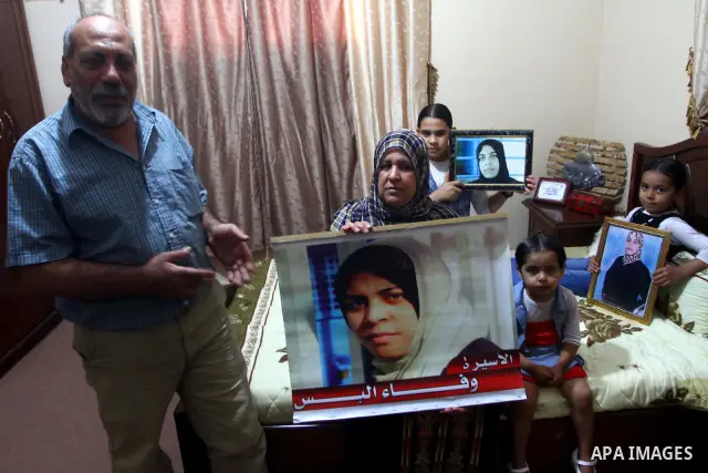 The family of Palestinian prisoner Wafa Albes hold portraits of her as they prepare their house for her upcoming release from an Israeli jail on Oct, 12, 2011 in the Jabalia refugee camp. Wafa has been jailed in Israel s...