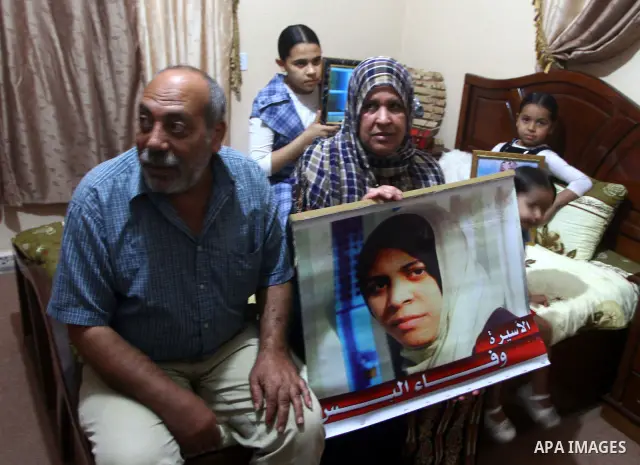 The family of Palestinian prisoner Wafa Albes hold portraits of her as they prepare their house for her upcoming release from an Israeli jail on Oct, 12, 2011 in the Jabalia refugee camp. Wafa has been jailed in Israel s...