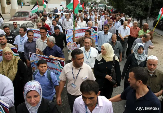 Palestinian UNRWA employees demonstrate in solidarity with prisoners jailed in Israel in front of the International Red Cross building in Gaza City, Wednesday, Oct. 12, 2011. Israelis welcomed on Wednesday a major prison...