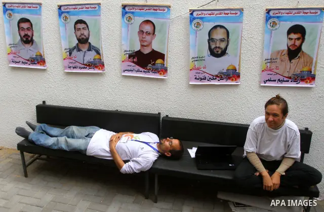 Pro-Palestinian activists sit at red cross headquarters during a rally by Palestinians after a prisoner swap between Hamas and Israel, in Gaza City October 12, 2011. Israelis welcomed on Wednesday a major prisoner swap t...