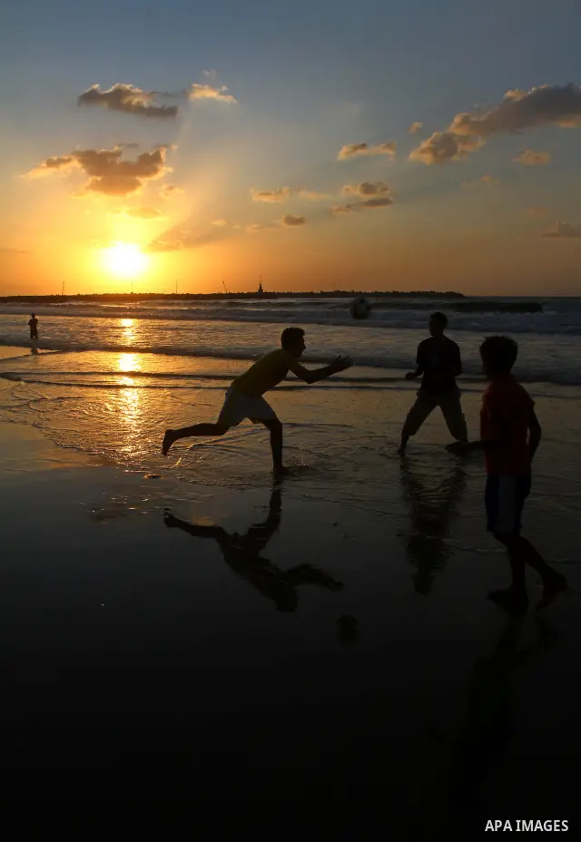 Children play football at the beach during sunset as Palestinians celebrating a prisoner swap between Hamas and Israel, in Gaza City October 12, 2011. Israelis welcomed on Wednesday a major prisoner swap that will free s...