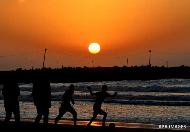 Children play football at the beach during sunset as Palestinians celebrating a prisoner swap between Hamas and Israel, in Gaza City October 12, 2011. Israelis welcomed on Wednesday a major prisoner swap that will free s...