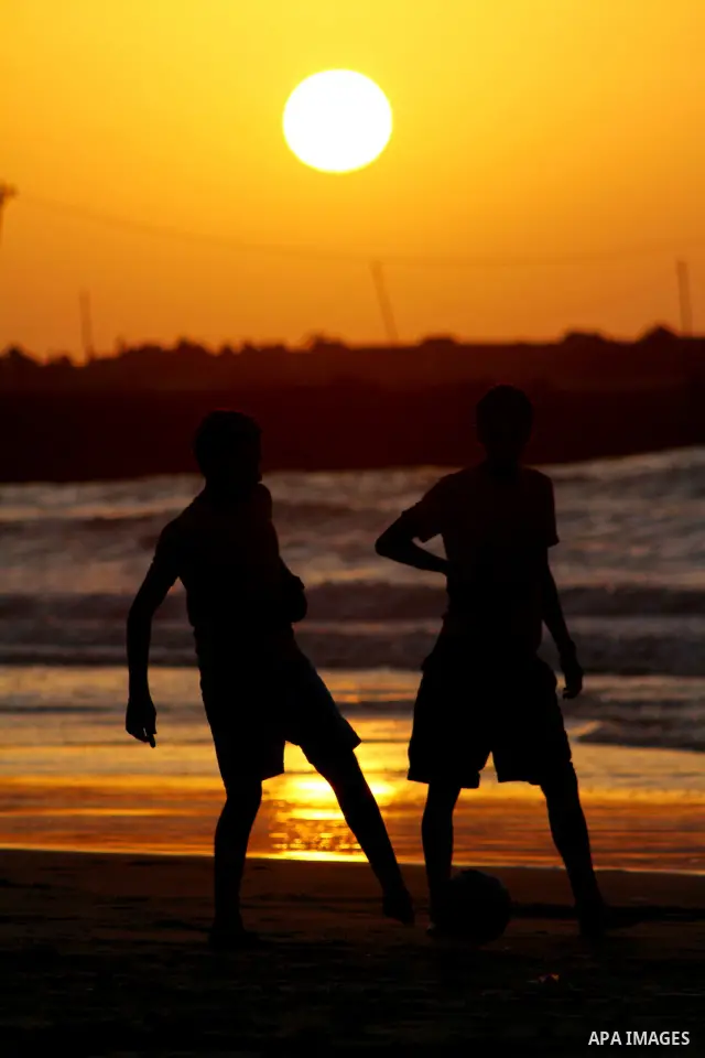 Children play football at the beach during sunset as Palestinians celebrating a prisoner swap between Hamas and Israel, in Gaza City October 12, 2011. Israelis welcomed on Wednesday a major prisoner swap that will free s...