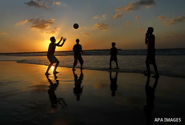 Children play football at the beach during sunset as Palestinians celebrating a prisoner swap between Hamas and Israel, in Gaza City October 12, 2011. Israelis welcomed on Wednesday a major prisoner swap that will free s...