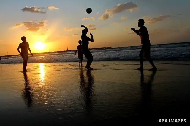 Children play football at the beach during sunset as Palestinians celebrating a prisoner swap between Hamas and Israel, in Gaza City October 12, 2011. Israelis welcomed on Wednesday a major prisoner swap that will free s...