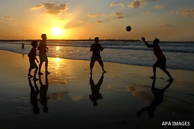 Children play football at the beach during sunset as Palestinians celebrating a prisoner swap between Hamas and Israel, in Gaza City October 12, 2011. Israelis welcomed on Wednesday a major prisoner swap that will free s...