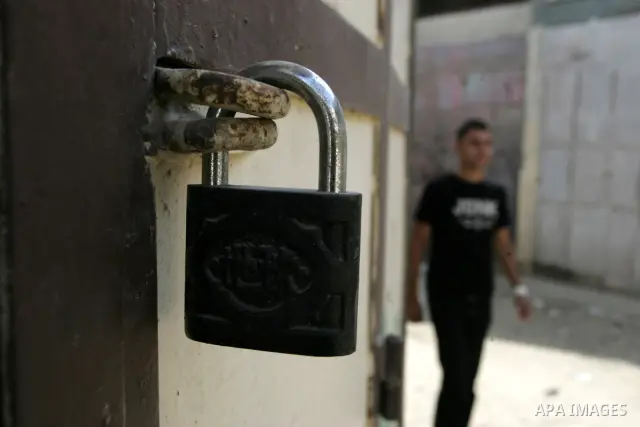 A Palestinian boy walks in front of closed shops following a two-hour strike in solidarity with Palestinian prisoners held in Israeli jails, in Rafah, southern Gaza Strip on October 13, 2011. According to an Israeli Pris...