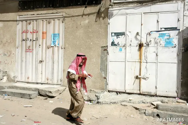 A Palestinian man walks in front of closed shops following a two-hour strike in solidarity with Palestinian prisoners held in Israeli jails, in Rafah, southern Gaza Strip on October 13, 2011. According to an Israeli Pris...