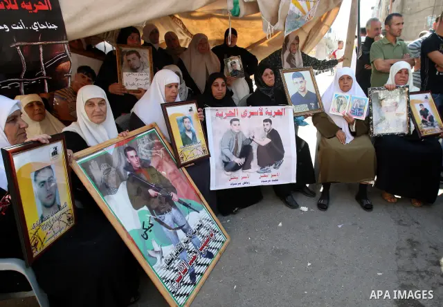 Palestinians take part in a rally supporting the prisoners in Israeli jails in the Askar refugee camp in the West Bank city of Nablus, Friday Oct. 14, 2011. The case of prisoners in Israeli jails is deeply sensitive for...