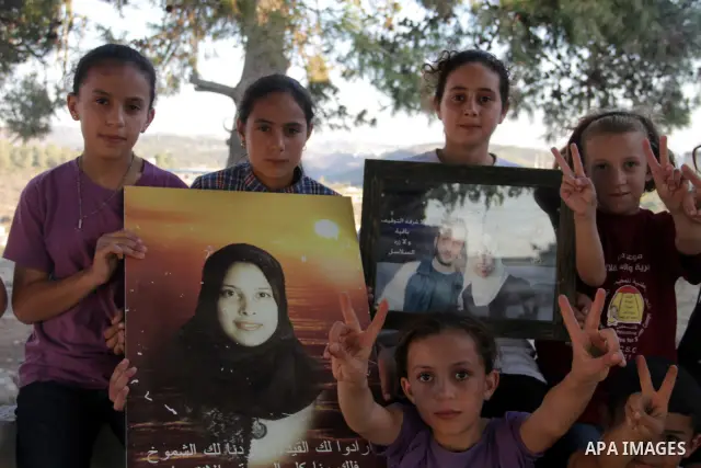 Palestinians from the village of Nabi Saleh celebrate the upcoming release of prisoner Ahlam Tamimi (portrait C-R), imprisoned in an Israeli jail since 2002 and sentenced to 16 life terms for an attack in Jerusalem at th...