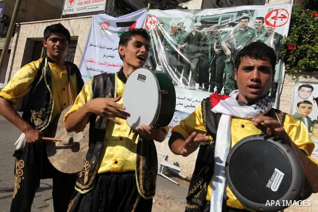 Palestinians celebrate the wedding of their friend and a prisoner swap between Hamas and Israel, in front of the headquarters of the International Red Cross in Gaza City October 14, 2011. Israeli soldier Gilad Shalit wil...