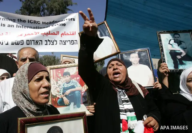 Palestinians hold photographs of their relatives held in Israeli jails during a protest calling for their release, next to the headquarters of the International Red Cross in Jerusalem, October 14, 2011. Israeli soldier G...