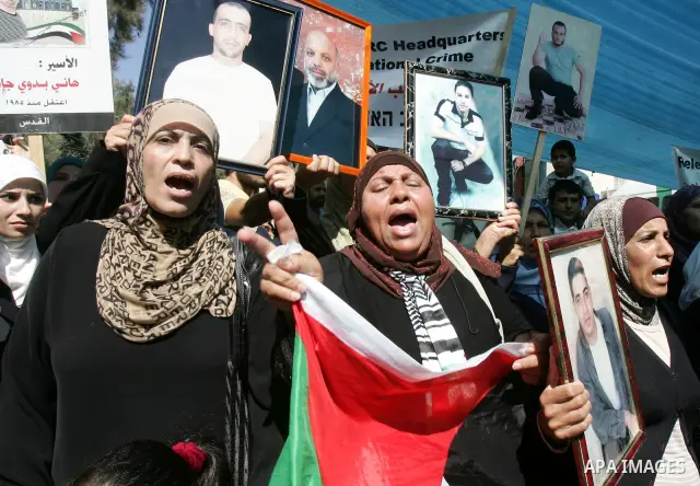 Palestinians hold photographs of their relatives held in Israeli jails during a protest calling for their release, next to the headquarters of the International Red Cross in Jerusalem, October 14, 2011. Israeli soldier G...