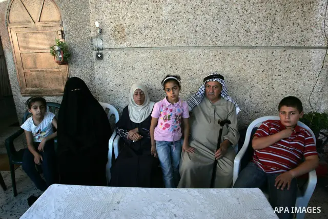 The family of Palestinian prisoner Nasser Nazzal show his picture as they gather at a relative's house in the southern Gaza Strip town of Khan Younis on October 15, 2011 awaiting his release as part of a deal to secure t...