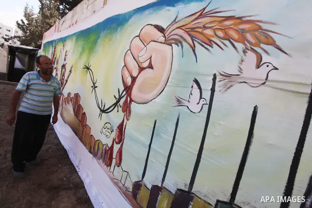 Palestinian artist paints a mural to talk about the challenge of young Palestinians with a high population of the world's 7 billion people in Gaza City, on Oct 16, 2011. Photo by Majdi Fathi