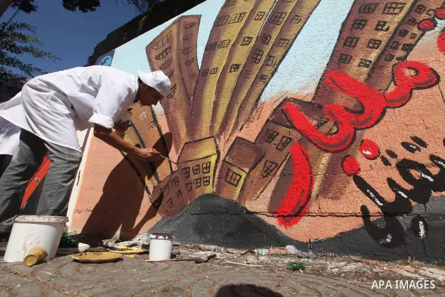 Palestinian artist paints a mural to talk about the challenge of young Palestinians with a high population of the world's 7 billion people in Gaza City, on Oct 16, 2011. Photo by Majdi Fathi