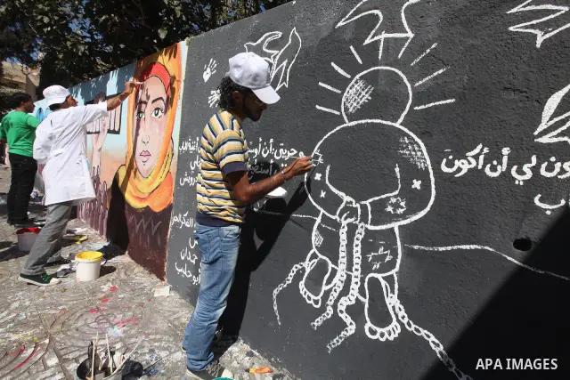 Palestinian artist paints a mural to talk about the challenge of young Palestinians with a high population of the world's 7 billion people in Gaza City, on Oct 16, 2011. Photo by Majdi Fathi