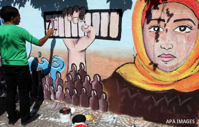 Palestinian artist paints a mural to talk about the challenge of young Palestinians with a high population of the world's 7 billion people in Gaza City, on Oct 16, 2011. Photo by Majdi Fathi