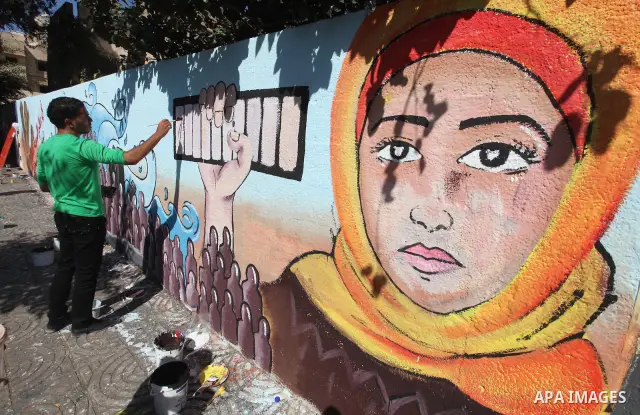 Palestinian artist paints a mural to talk about the challenge of young Palestinians with a high population of the world's 7 billion people in Gaza City, on Oct 16, 2011. Photo by Majdi Fathi