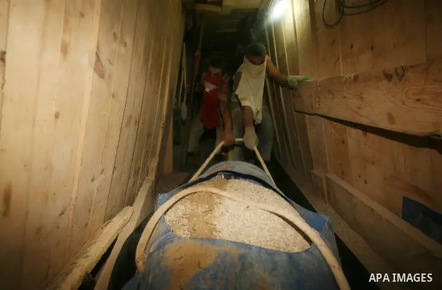 Palestinian men smuggle gravels into the Gaza Strip through a tunnel under the Egypt-Gaza border in Rafah on Oct. 16, 2011. Israel released a list of 477 Palestinian prisoners to be released next week as part of the deal...
