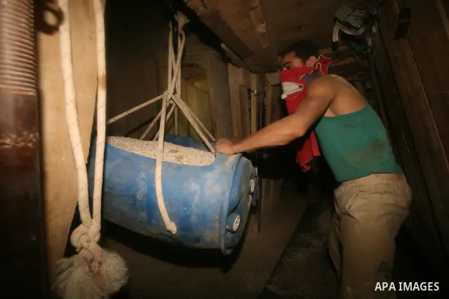 Palestinian men smuggle gravels into the Gaza Strip through a tunnel under the Egypt-Gaza border in Rafah on Oct. 16, 2011. Israel released a list of 477 Palestinian prisoners to be released next week as part of the deal...