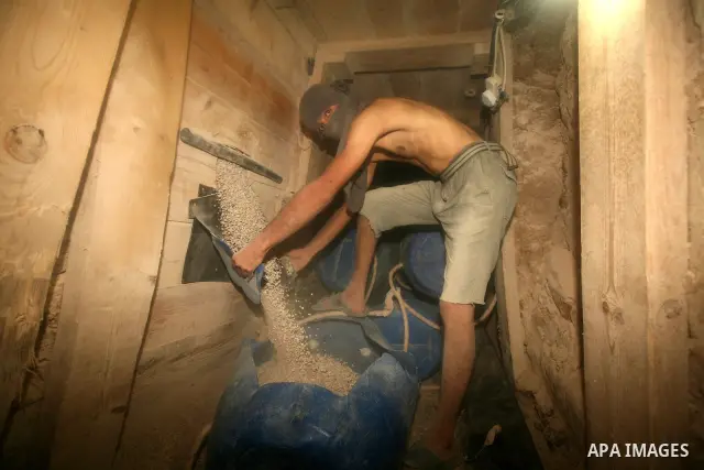 Palestinian men smuggle gravels into the Gaza Strip through a tunnel under the Egypt-Gaza border in Rafah on Oct. 16, 2011. Israel released a list of 477 Palestinian prisoners to be released next week as part of the deal...