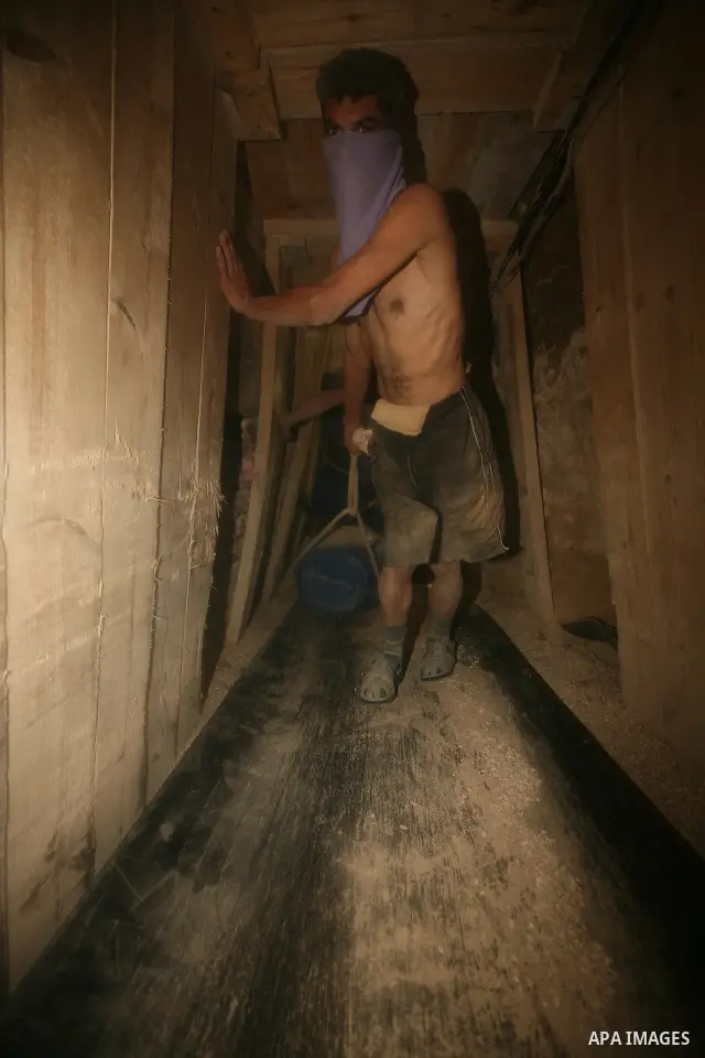 Palestinian men smuggle gravels into the Gaza Strip through a tunnel under the Egypt-Gaza border in Rafah on Oct. 16, 2011. Israel released a list of 477 Palestinian prisoners to be released next week as part of the deal...