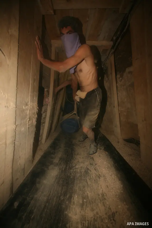 Palestinian men smuggle gravels into the Gaza Strip through a tunnel under the Egypt-Gaza border in Rafah on Oct. 16, 2011. Israel released a list of 477 Palestinian prisoners to be released next week as part of the deal...