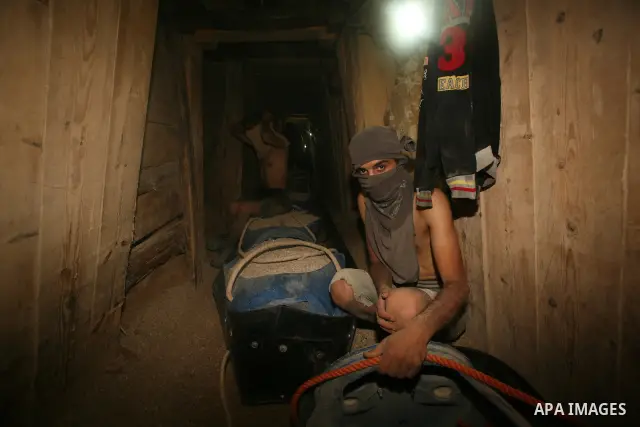 Palestinian men smuggle gravels into the Gaza Strip through a tunnel under the Egypt-Gaza border in Rafah on Oct. 16, 2011. Israel released a list of 477 Palestinian prisoners to be released next week as part of the deal...