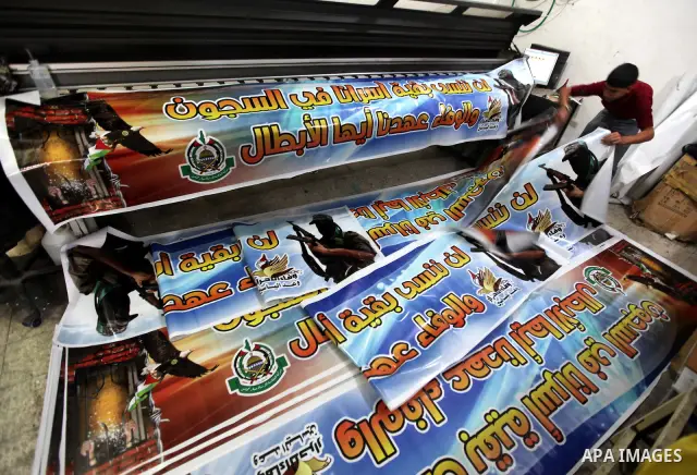 Palestinians print posters in preparation for a prisoner swap between Hamas and Israel in Gaza City, Sunday, Oct. 16, 2011. Relatives of Israelis killed in Palestinian attacks waged a charged debate Sunday over the plann...