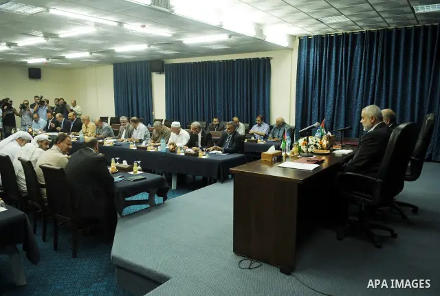 Palestinian Prime Minister in Gaza Strip, Ismail Haniyeh attends a meeting with his ministers and legislators in his office in Gaza City, Sunday, Oct. 16, 2011. The relatives of Israelis killed in Palestinian attacks wag...