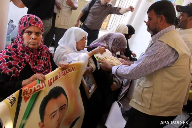 Relatives of Palestinian prisoners eat sweets as they celebrate the upcoming release of Palestinian inmates held in Israeli jails, on Oct. 17, 2011 at the Red Cross' offices in Gaza City. Under a prisoner swap deal signe...