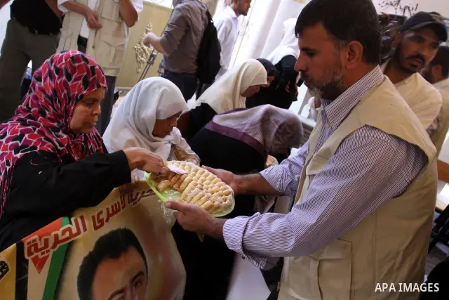 Relatives of Palestinian prisoners eat sweets as they celebrate the upcoming release of Palestinian inmates held in Israeli jails, on Oct. 17, 2011 at the Red Cross' offices in Gaza City. Under a prisoner swap deal signe...
